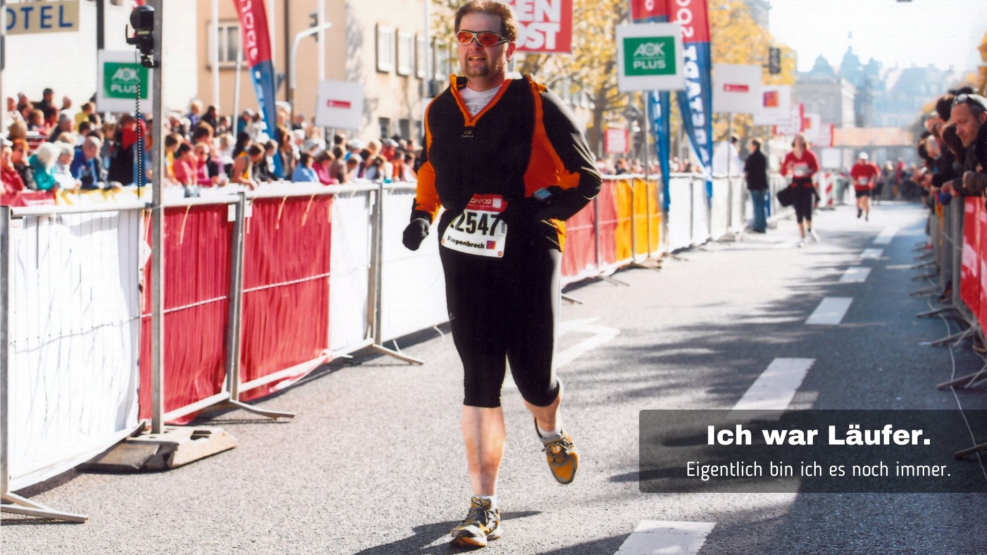Norbert Beck läuft beim Dresden-Marathon auf einer abgesperrten Straße vor Zuschauern mit dem Text „Ich war Läufer.“.